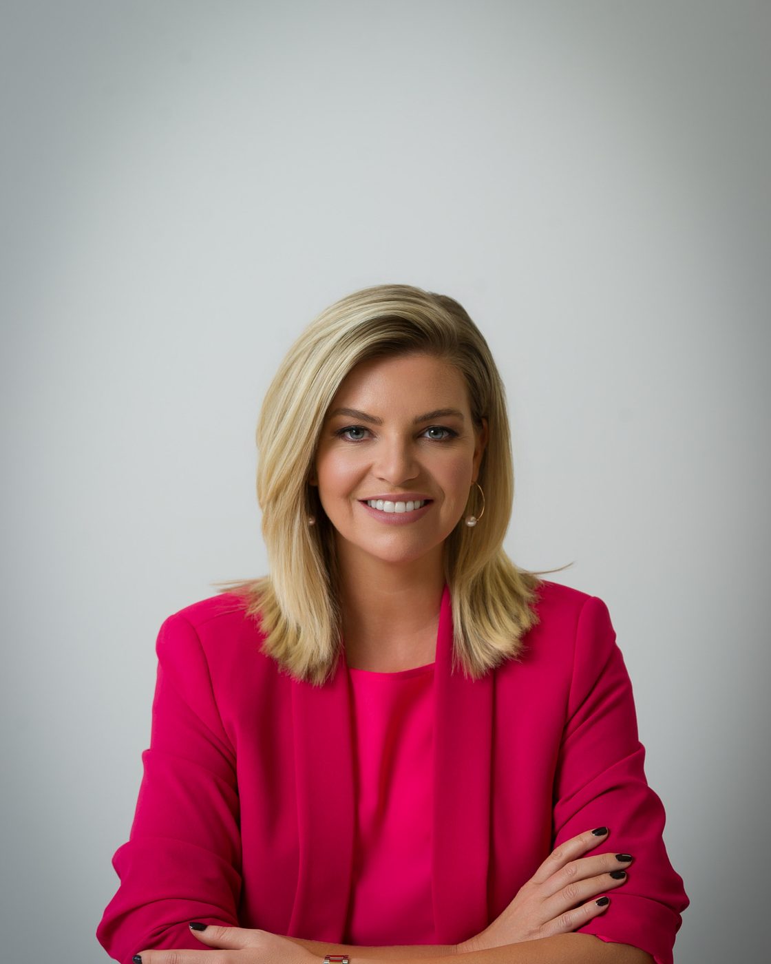 Headshot of a woman in a bright pink blazer