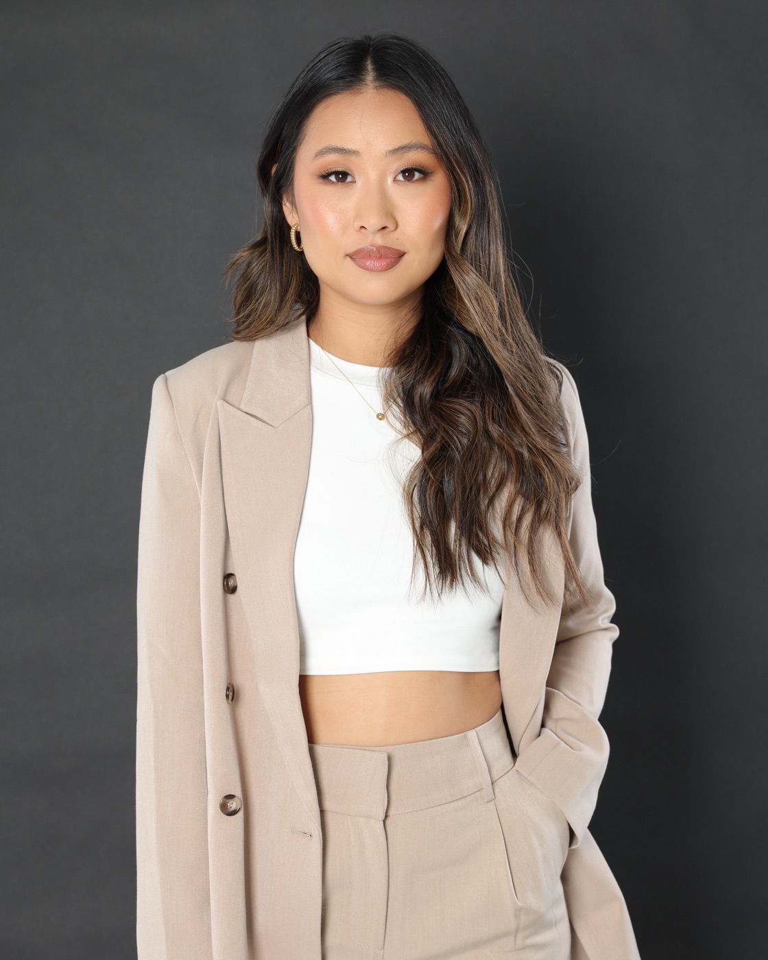 Studio portrait in a beige suit and white crop top